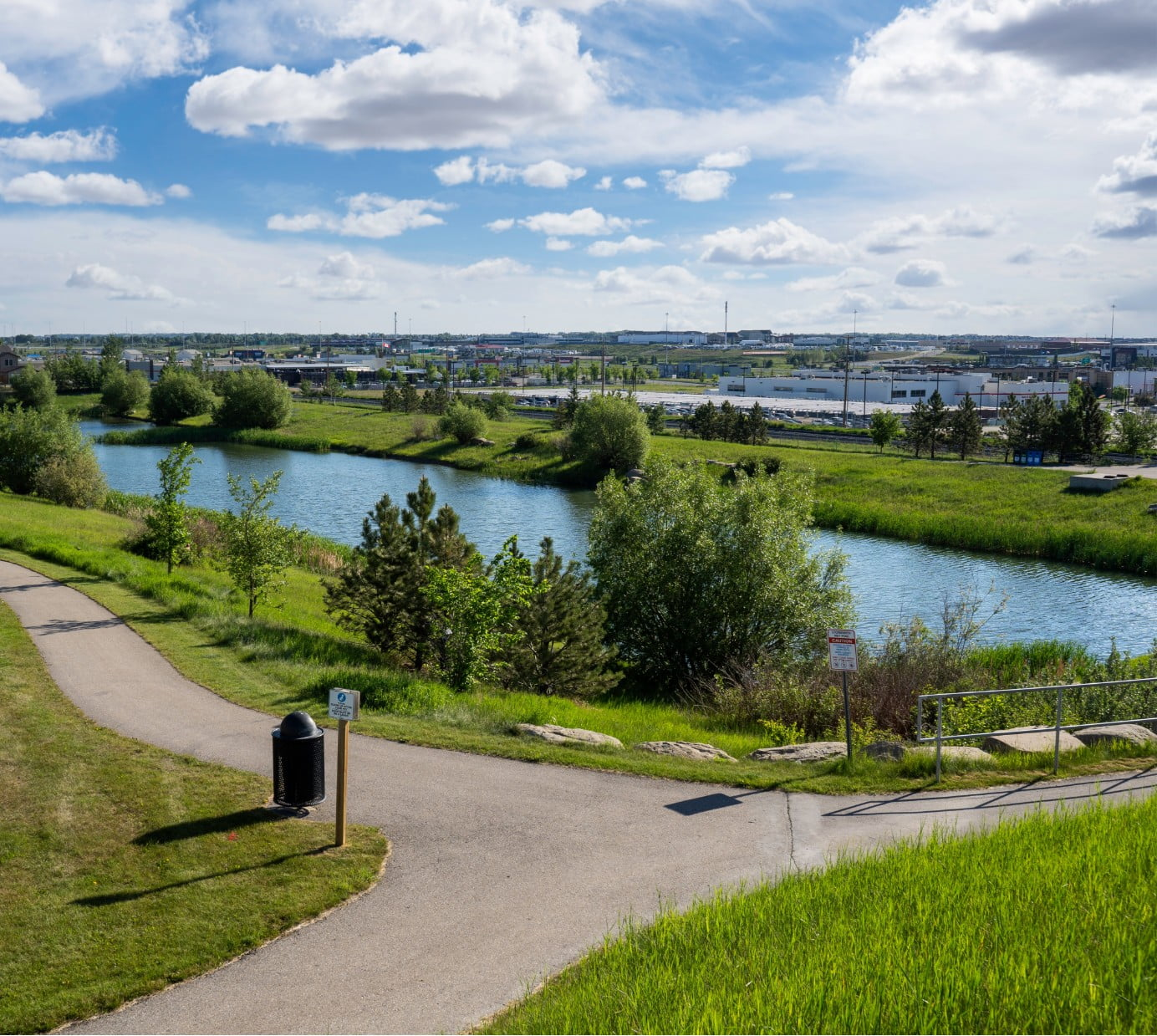 A picture of a park with a pond and pathways