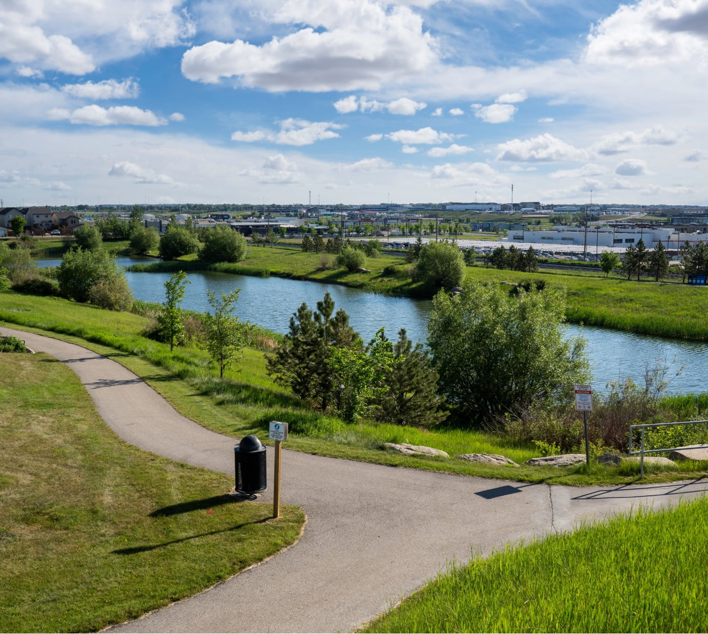A picture of a park with a pond and pathways