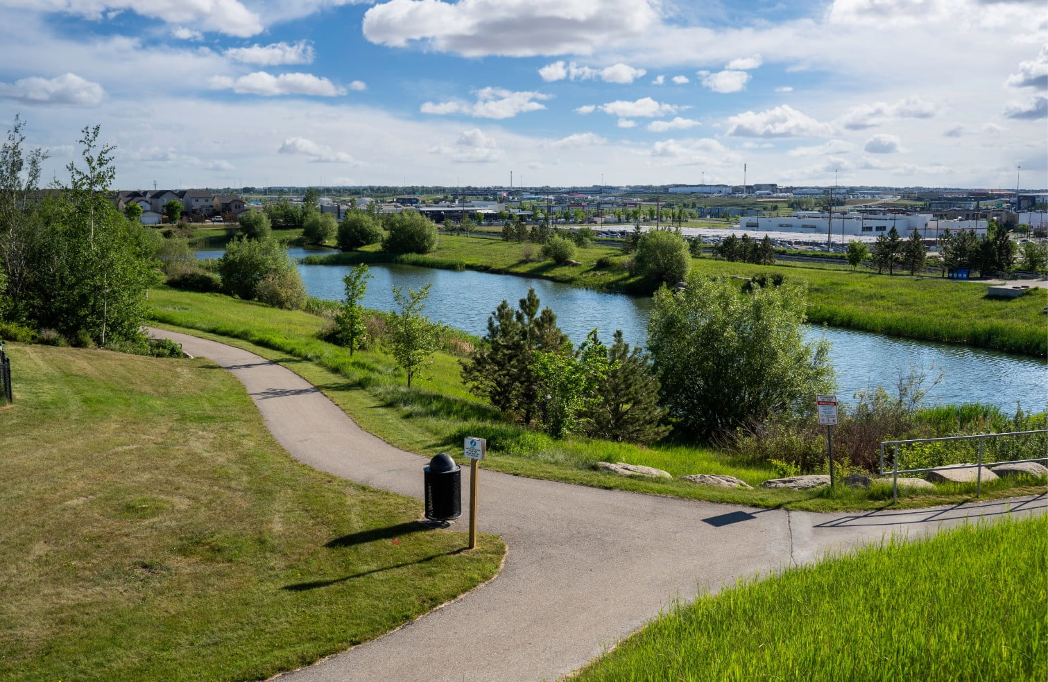 A picture of a park with a pond and pathways