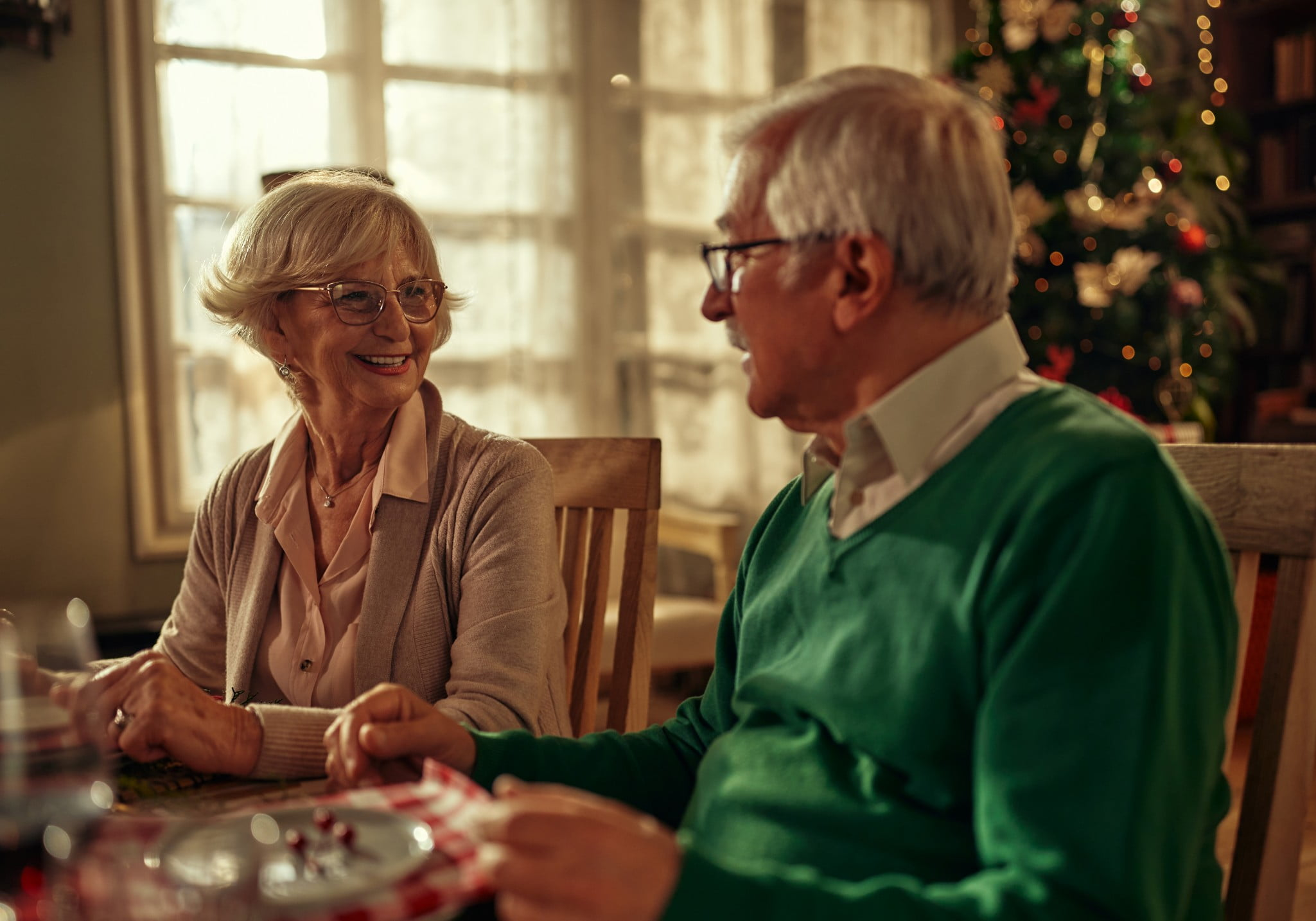 An elderly couple having a Christmas dinner together.
