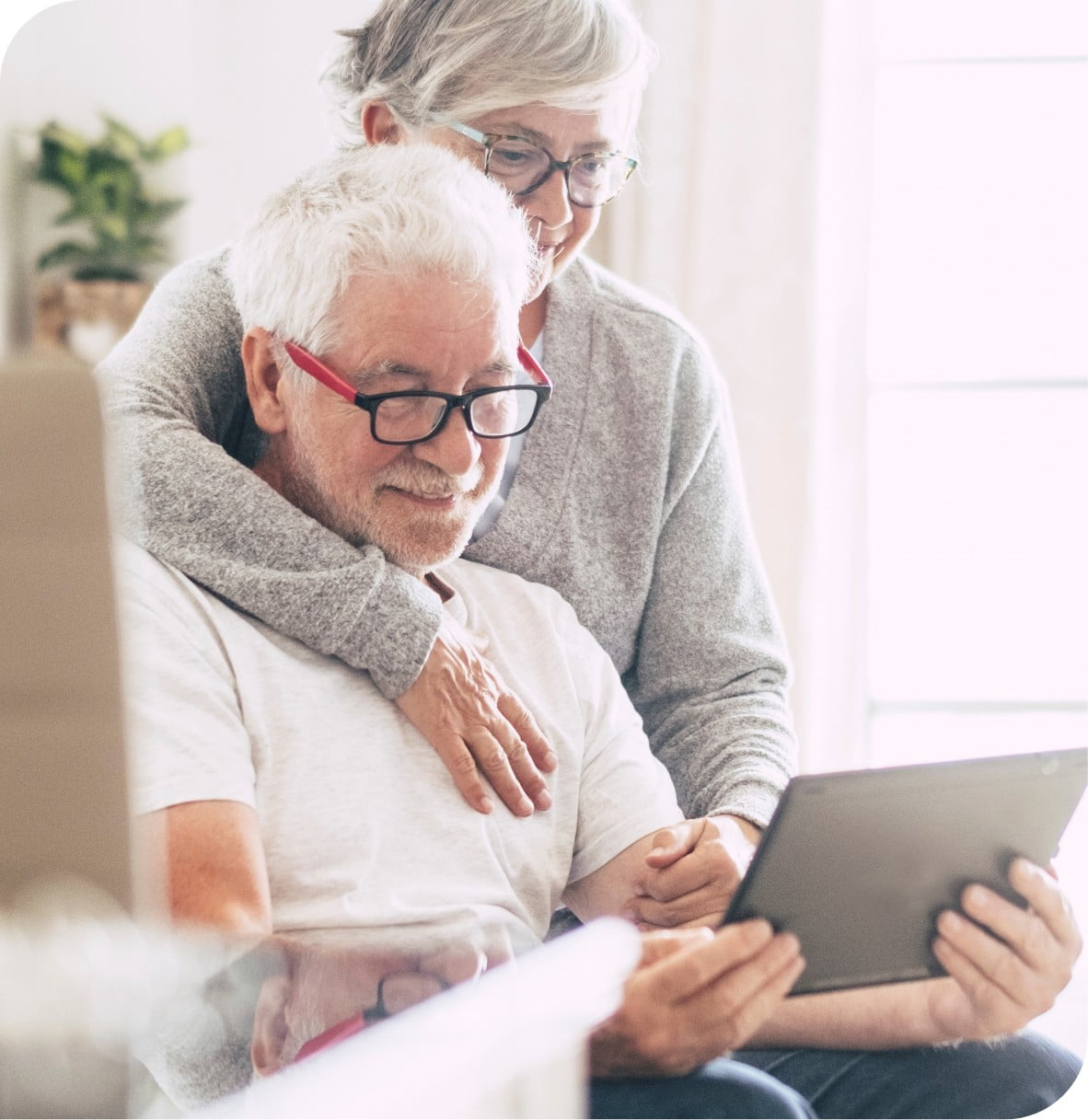 an elderly couple with the man on a laptop.