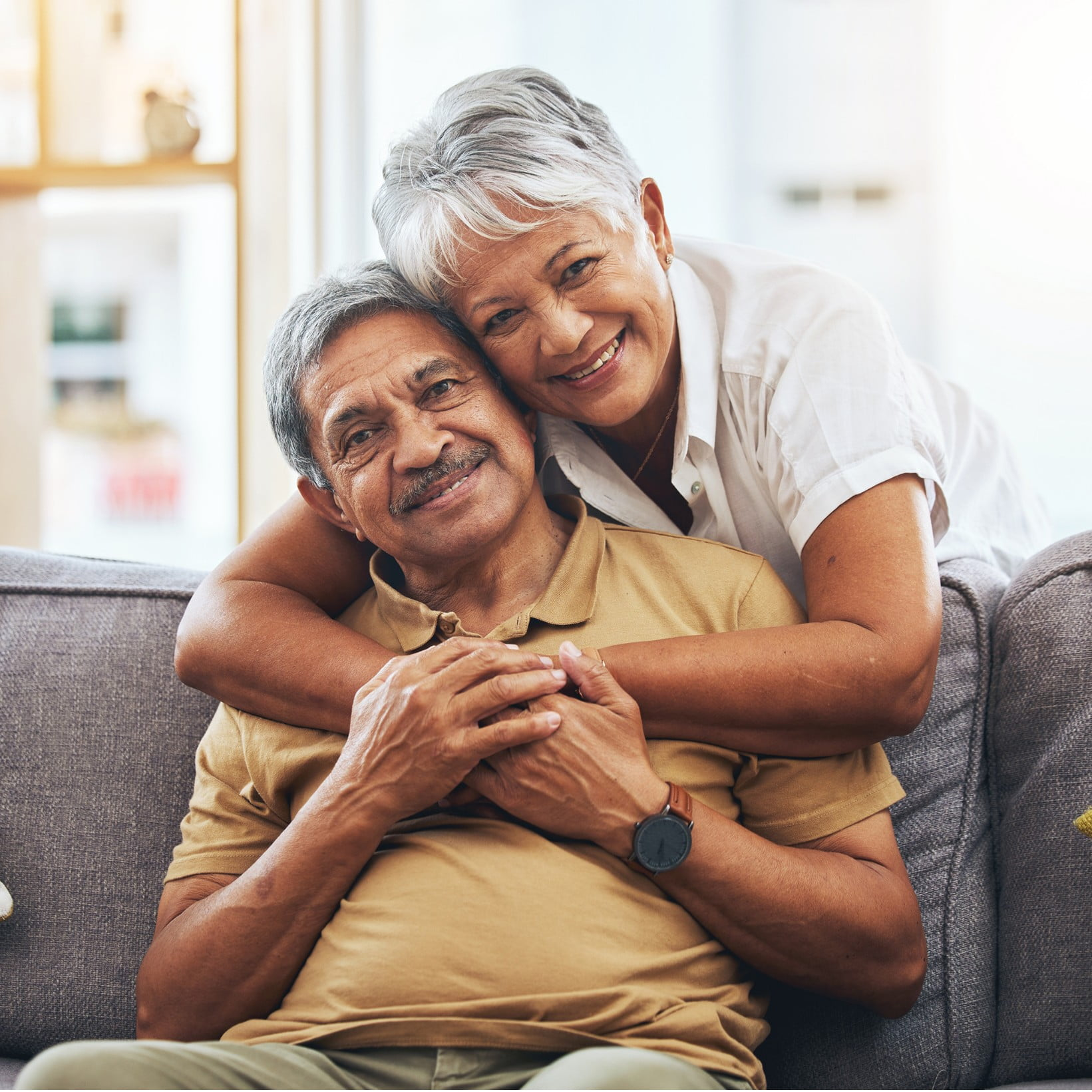 A woman hugging a man on a couch