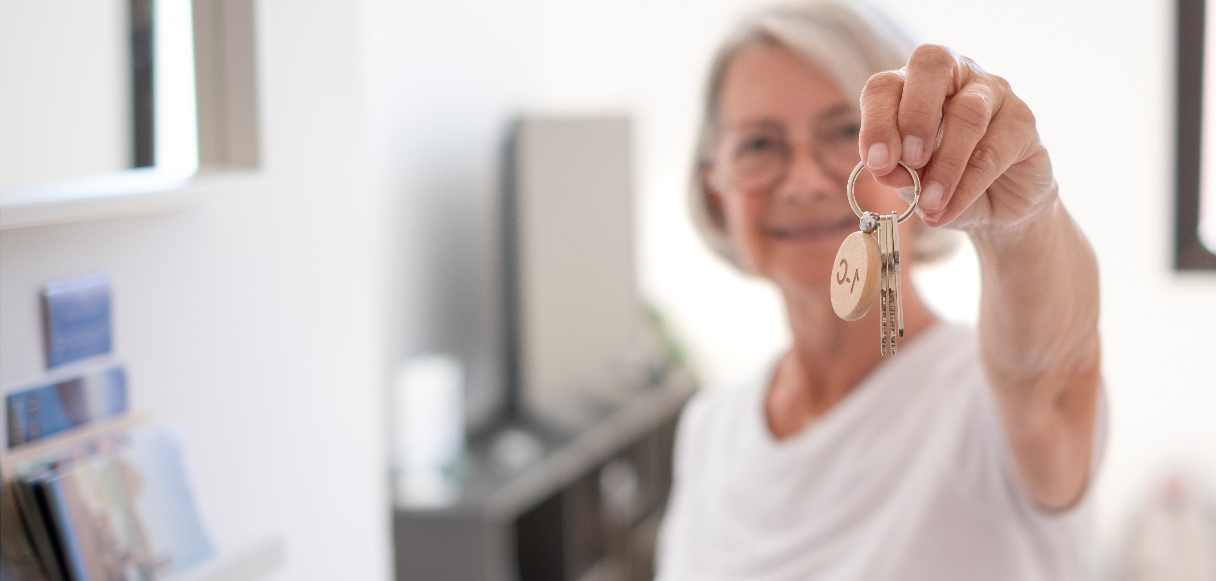 an elderly lady holding up a set of keys
