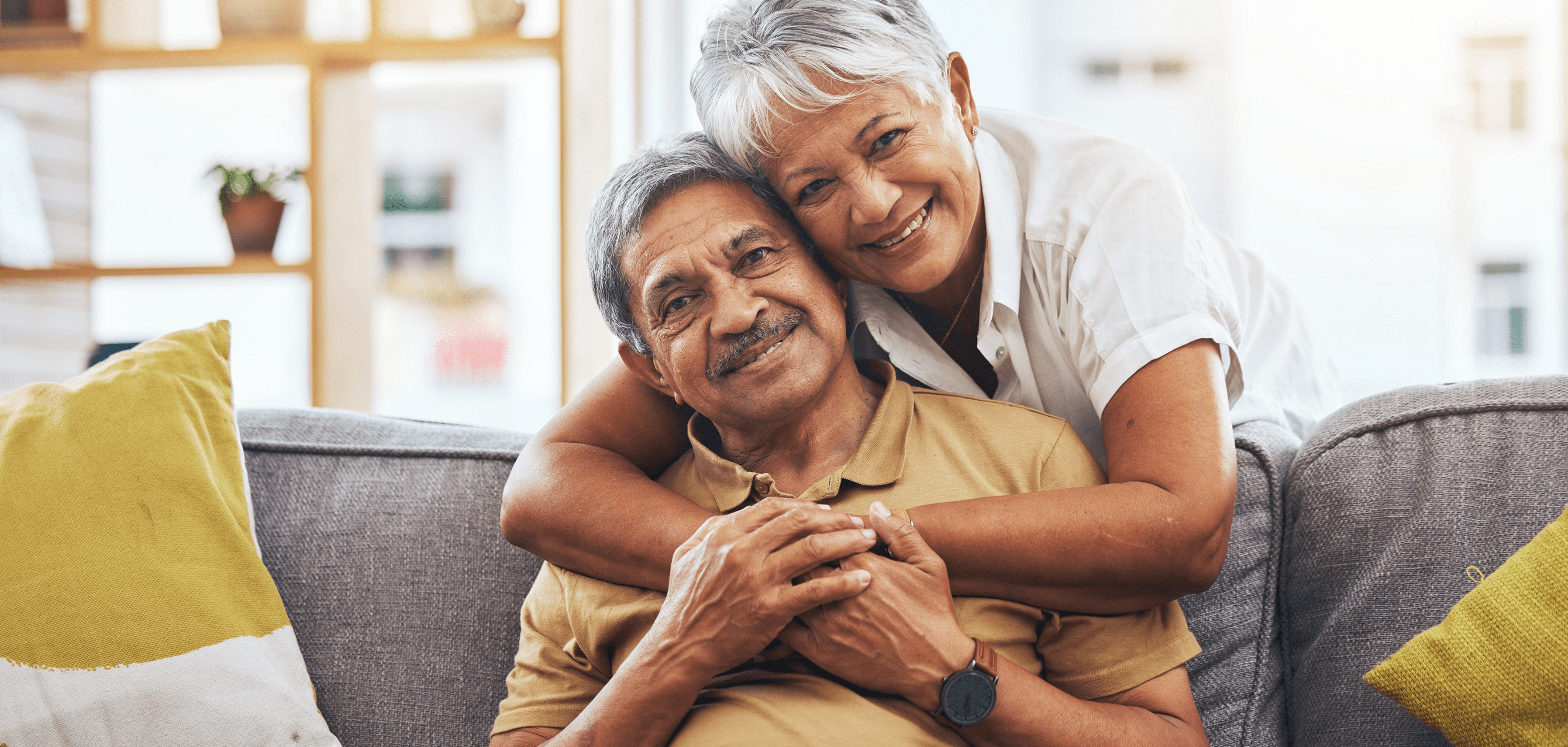 A woman hugging a man on a couch